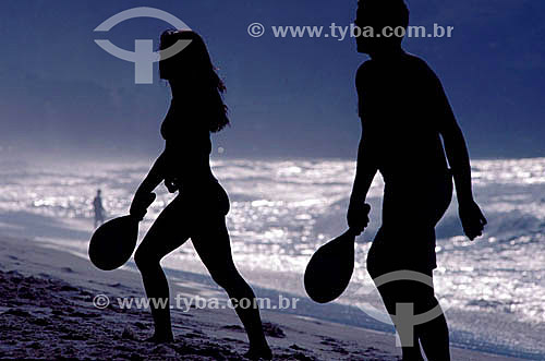  Leisure - silhouette of a couple playing Frescobol (kind of racketball played mainly on the beach) 