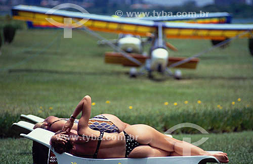  Ultralights parked with women wearing bikinis in the first plan 