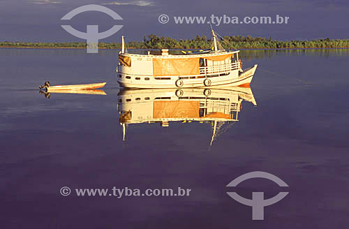  A style of boat typical to Amazonian region, reflected on the calm waters of the Araguari River - Amapa state - Brazil 