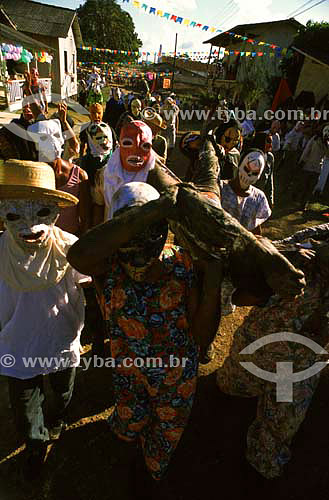  People using masks carrying a figure in the Religious festival of St. James - Mazagao county - Amapa state - Brazil 