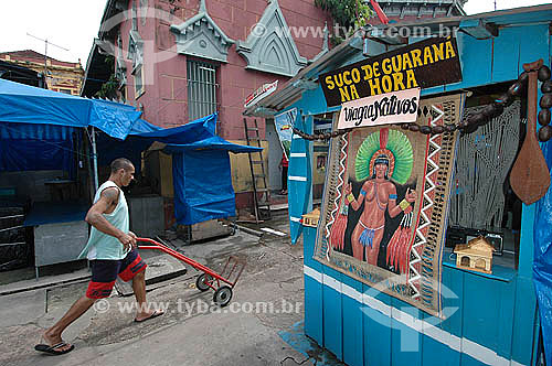  Man passing with wheelbarrow among stalls selling  guarana beverage in Manaus city market - Amazonas state - Brazil 