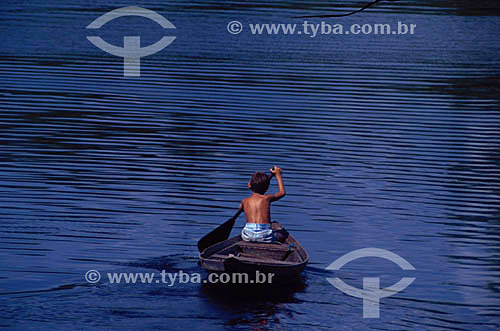  Boy rowing canoe on Rio Negro (Black River) - Amazonas state - Brazil 