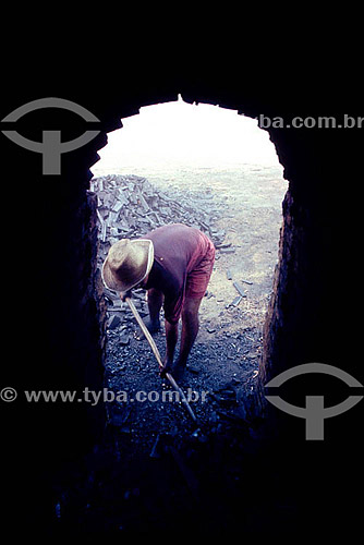  Inhabitant of the Amazonian - Charcoal burner working the charcoal with a shovel - Amazonas state - Brazil   