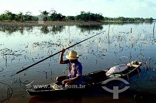 Fisherman in a canoe using a lance to fish the Pirarucu (Arapaima gigas) - Japura River - Amazonas state - Brazil 