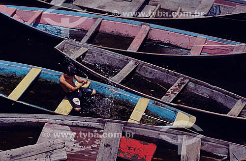  Boy playing with water on a canoe - Rio Negro (Black River) - Amazonas state - Brazil 