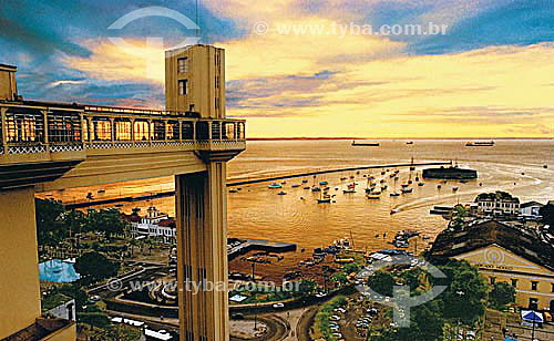  Sunset in Salvador historical city: Elevador Lacerda (Lacerda Elevator) to the left with Mercado Modelo below to the right and Forte São Marcelo (Sao Marcelo Fort) (1) with boats around on Baía de Todos os Santos (All Saints Bay) in the background - 