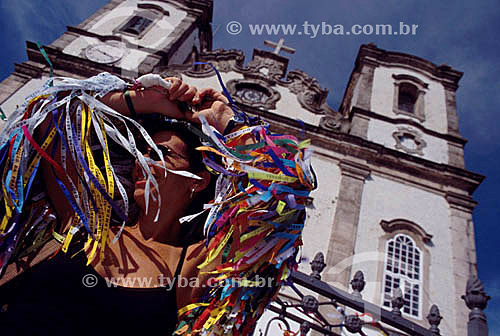  Woman in front of the Nosso Senhor do Bonfim Church* with the face covered by the strips of Nosso Senhor do Bonfim (Ours Mister of Bonfim) that are tied to the people`s pulse to bring luck - Salvador city - Bahia state - Brasil   * The church is a N 