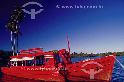  Red boat with coconut trees and blue sky on the sea of the of Itaparica Island * - Bahia state - Brazil  * The Itaparica Island is situated in the Baia de Todos os Santos (All Saints Bay) and its architectural and town planning joint is a National H 