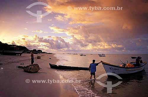  Fisherman pulling a boat and person stand on the sand - Superagui Village - Parana state - Brazil 