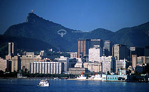  View of the center of Rio de Janeiro city as seen from Guanabara Bay showing the ferry which transports people between Rio de Janeiro and Niteroi, with Ilha Fiscal (*) to the right and Cristo Redentor (Christ the Redeemer) high in the background - R 