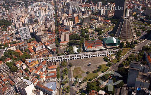  Aerial view of  Rio de Janeiro city downtown, showing the conical São Sebastião do Rio de Janeiro`s Cathedral (or Metropolitan Cathedral), the Petrobras Building (in cubes behind the cathedral) and the BNDES building. To the right one can see the 