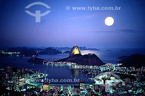  Panoramic view of the moon rising above Sugar Loaf Mountain* at twilight with the city lights of Botafogo Cove in the foreground and the city of Niteroi in the background - Rio de Janeiro city - Rio de Janeiro state - Brazil  *Commonly called Sugar  