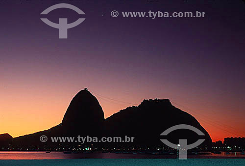  Silhouette of Sugar Loaf Mountain* with the lights of the Urca district below at dawn - Rio de Janeiro city - Rio de Janeiro state - Brazil  *Commonly called Sugar Loaf Mountain, the entire rock formation also includes Urca Mountain and Sugar Loaf i 