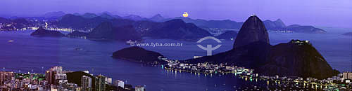  Panoramic view of Sugar Loaf Mountain* at dawn with the lights of Botafogo Cove in the foreground - Rio de Janeiro city - Rio de Janeiro state - Brazil *Commonly called Sugar Loaf Mountain, the entire rock formation also includes Urca Mountain and S 