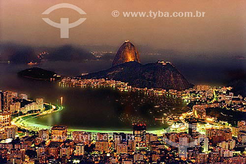  Panoramic view of Sugar Loaf Mountain* at sunset with the lights of Botafogo Cove in the foreground - Rio de Janeiro city - Rio de Janeiro state - Brazil  *Commonly called Sugar Loaf Mountain, the entire rock formation also includes Urca Mountain an 
