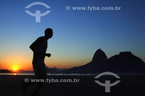  Leisure - silhouette of person jogging with the Sugar Loaf Mountain* in the background in the sunrising - Botafogo Beach - Rio de Janeiro city - Rio de Janeiro state - Brazil *Commonly called Sugar Loaf Mountain, the entire rock formation also inclu 
