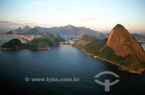  Aerial view of Praia Vermelha (Red Beach) at sunset, with the neighborhood of Botafogo behind it. Sugar Loaf Mountain (1) is to the right, and Morro da Babilonia (Babylonia Mountain) (2) is to the left, followed by Copacabana Beach. In the backgroun 