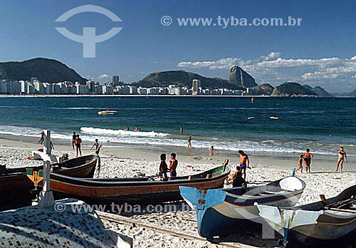  Fishing boats resting on Copacabana Beach, with fishermen and people walking along the beach, and Sugar Loaf Mountain in the background - Rio de Janeiro city - Rio de Janeiro state - Brazil 