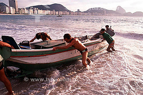  Fishermen removing their boat from the Atlantic Ocean on Copacabana Beach - Rio de Janeiro city - Rio de Janeiro state - Brazil 