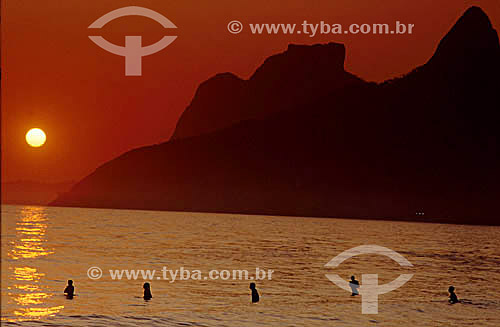  Sunset at Ipanema Beach with the silhouettes of surfers in the water and Rock of Gavea* in the background - Rio de Janeiro city - Rio de Janeiro state - Brazil  * The Rock of Gavea is a National Historic Site since 08-08-1973. 