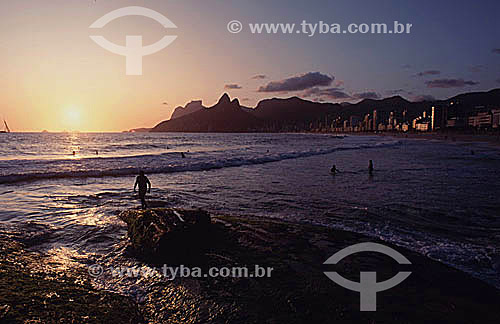  People on Ipanema Beach at sunset with Rock of Gavea and Morro Dois Irmaos (Two Brothers Mountain) in the background - Rio de Janeiro city - Rio de Janeiro state - Brazil 