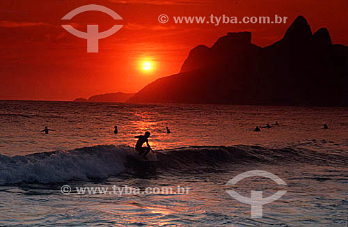  Silhouette of surfers on Ipanema Beach at sunset, with Rock of Gavea and Morro Dois Irmaos (Two Brothers Mountain)* in the background - Rio de Janeiro city - Rio de Janeiro state - Brazil  * The Gavea Rock and the Two Brothers Mountain are National  
