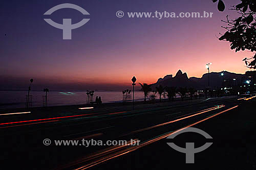  Sunset on Ipanema Beach with Rock of Gavea and Morro Dois Irmaos (Two Brothers Mountain) in the background and the lights of cars passing in the foreground - Rio de Janeiro city - Rio de Janeiro state - Brazil 