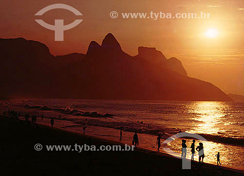  Silhouette of people on Ipanema Beach at sunset with Rock of Gavea and Morro Dois Irmaos (Two Brothers Mountain)* in the background - Rio de Janeiro city - Rio de Janeiro state - Brazil  * The Gavea Rock and the Two Brothers Mountain are National Hi 