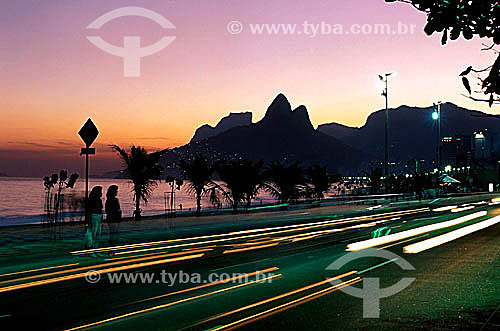  Sunset on Ipanema Beach with Rock of Gavea and Morro Dois Irmaos (Two Brothers Mountain)* in the background with the lights of cars moving in the foreground - Rio de Janeiro city - Rio de Janeiro state - Brazil  * The Gavea Rock and the Two Brothers 