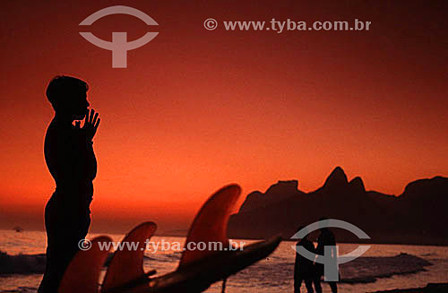  Silhouette of a surfer on Ipanema Beach at sunset with Rock of Gavea and Morro Dois Irmaos (Two Brothers Mountain)* in the background - Rio de Janeiro city - Rio de Janeiro state - Brazil  * The Gavea Rock and the Two Brothers Mountain are National  