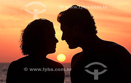  Silhouette of a couple with the sun setting in between them - Ipanema neighborhood - Rio de Janeiro city - Rio de Janeiro state - Brazil 