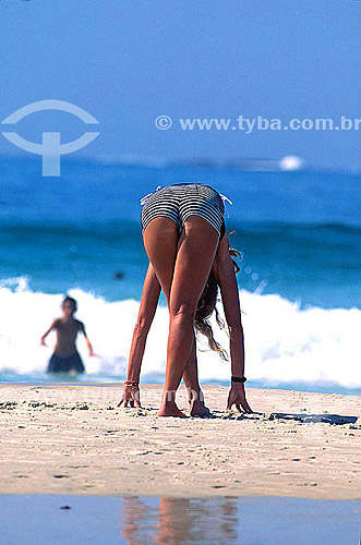  Woman stretching in the sand on Ipanema Beach - Rio de Janeiro city - Rio de Janeiro state - Brazil 