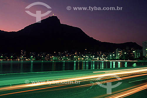  Lagoa Rodrigo de Freitas (Rodrigo de Freitas Lagoon)* at sunset with Cristo Redentor (Christ the Redeemer) in the background and the lights of cars moving in the foreground - Rio de Janeiro city - Rio de Janeiro state - Brazil  * National Historic S 