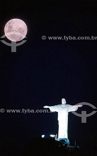  The moon rising above the brightly illuminated Cristo Redentor (Christ the Redeemer) at night - Rio de Janeiro city - Rio de Janeiro state - Brazil 