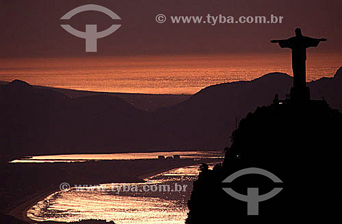  Silhouette of Cristo Redentor (Christ the Redeemer) atop Morro do Corcovado (Corcovado Mountain), with a golden sunset reflected on the waters of Atlantic Ocean and Guanabara Bay - Rio de Janeiro city - Rio de Janeiro state - Brazil 