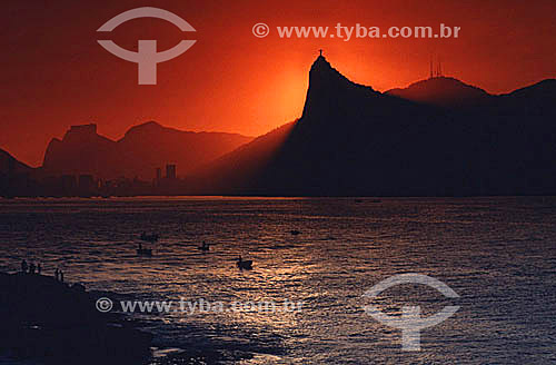  Silhouette of Christ the Redeemer at Morro do Corcovado (Corcovado Mountain) at sunset, as seen from the city of Niteroi, with Rock of Gavea to the left and the radio transmission towers of Sumare in the background - Rio de Janeiro city - Rio de Jan 