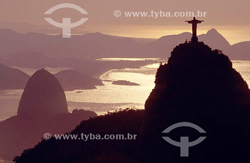  The Cristo Redentor (Statue of Christ the Redeemer) at sunset with the Sugar Loaf Mountain in the background - Niteroi city - Rio de Janeiro state - Brazil 