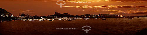  Panoramic view of the Cristo Redentor (Christ the Redeemer) on Corcovado Mountain as seen from the Urca district with boats on Guanabara Bay and buildings along Botafogo and Flamengo beaches at sunset - Rio de Janeiro city - Rio de Janeiro state - B 