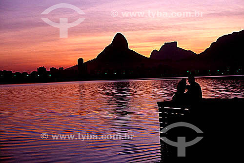  Lagoa Rodrigo de Freitas (Rodrigo de Freitas Lagoon) (1) at sunset, with the silhouettes of a couple sitting on a pier in the foreground and Morro Dois Irmaos (Two Brothers Mountain) and Rock of Gavea (2) in the background to the right - Rio de Jane 