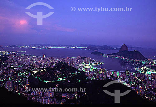  Panoramic view of Sugar Loaf Mountain* at sunset, surrounded by the city lights, with, from left to right, the entrance to Guanabara Bay, the beaches and buildings of Botafogo and Flamengo, and Santos Dumont Airport, and in the far background, the c 