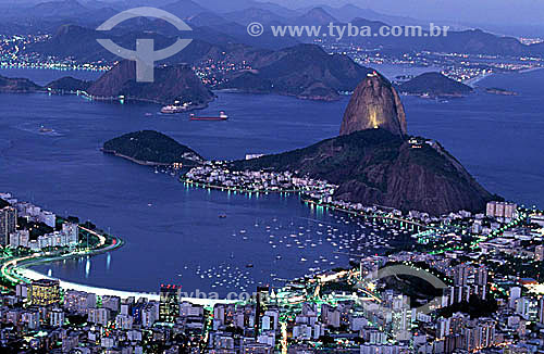  Panoramic view of Sugar Loaf Mountain* at twilight, surrounded by the lights from buildings in the neighborhoods of Urca and Botafogo, and the city of Niteroi in the far background - Rio de Janeiro - The Sugar Loaf Mountain* as seen from Guanabara B 