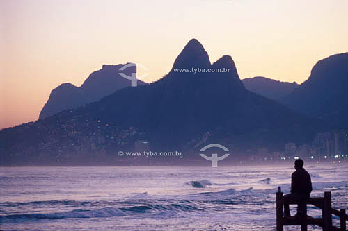  Silhouette of a man in the foreground with the Gavea Rock and the Morro Dois Irmaos (Two Brothers Mountain)* in the background  - Rio de Janeiro city - Rio de Janeiro state - Brazil  * The Rock of Gavea and the Two Brothers Mountain are National His 