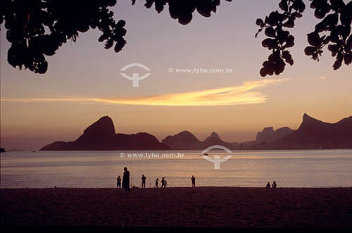  Silhouette of people on Icarai Beach at sunset with a view of Rio de Janeiro in the background showing, from left to right:  the Sugar Loaf Mountain, the Morro dos Dois Irmaos (Two Brothers Mountain), the Rock of Gavea and the Cristo Redentor (Chris 
