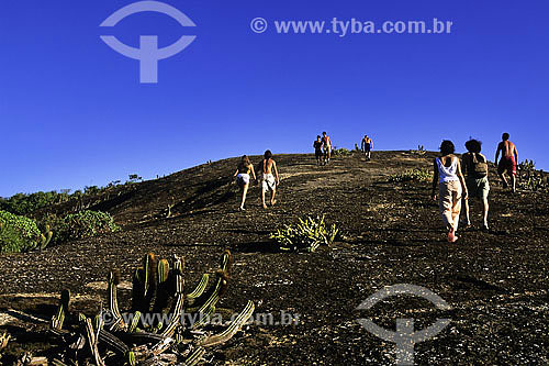  People walking up stone in Itacoatiara region - Niteroi city - Rio de Janeiro state - Brazil 