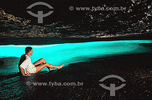 Man sitting inside Gruta do Acaia (Acaia Grotto), admiring the illuminated water, an effect created by the sunlight from outside - Praia do Acaia (Acaia Beach) - Ilha Grande (Big Island) - APA dos Tamoios (Tamoios Ecological Reserve) - Costa Verde ( 