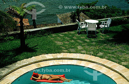  Woman sunbathing in a hotel pool -- Buzios city - Costa do Sol (Sun Coast) - Regiao dos Lagos (Lakes Region) - Rio de Janeiro state - Brazil 