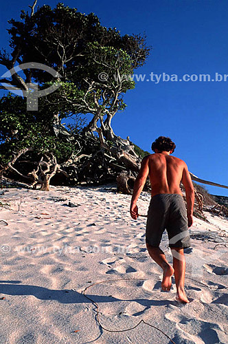  Young man walking on Ilha do Farol (Lighthouse Island) - Arraial do Cabo city - Costa do Sol (Sun Coast) - Regiao dos Lagos (Lakes Region) - Rio de Janeiro state - Brazil 