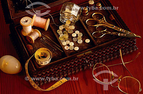  Glasses and sewing box objects:  shear, line, button, tape measure and needle 