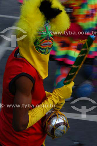  Reveller with a music instrument dressed up for the Carnival street party - 