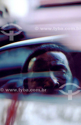  Reflex of a man`s face over a car mirror   